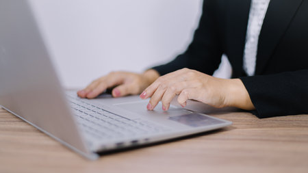 Close up of businesswoman hands typing on laptop computer in office.の写真素材