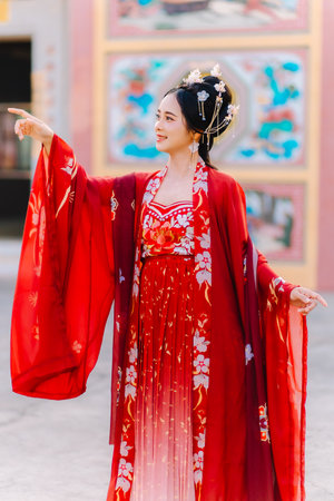 Woman dress China New year. portrait of a woman. person in traditional costume. woman in traditional costume. Beautiful young woman in a bright red dress and a crown of Chinese Queen posing.の写真素材