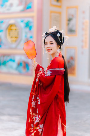 Woman dress China New year. portrait of a woman. person in traditional costume. woman in traditional costume. Beautiful young woman in a bright red dress and a crown of Chinese Queen posing.の写真素材