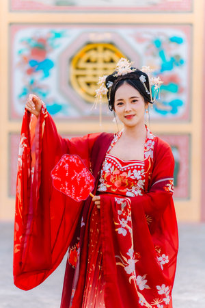 Woman dress China New year. portrait of a woman. person in traditional costume. woman in traditional costume. Beautiful young woman in a bright red dress and a crown of Chinese Queen posing.の写真素材