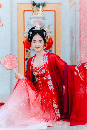 Woman dress China New year. portrait of a woman. person in traditional costume. woman in traditional costume. Beautiful young woman in a bright red dress and a crown of Chinese Queen posing.の写真素材