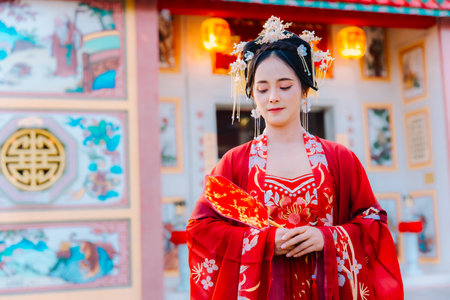Woman dress China New year. portrait of a woman. person in traditional costume. woman in traditional costume. Beautiful young woman in a bright red dress and a crown of Chinese Queen posing.の写真素材