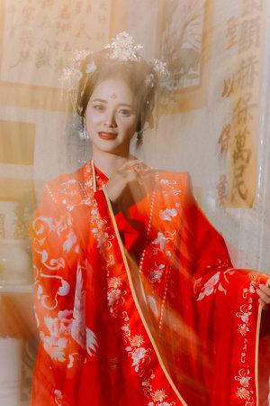 Woman dress China New year. portrait of a woman. person in traditional costume. woman in traditional costume. Beautiful young woman in a bright red dress and a crown of Chinese Queen posing.の写真素材