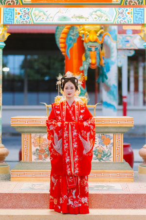Woman dress China New year. portrait of a woman. person in traditional costume. woman in traditional costume. Beautiful young woman in a bright red dress and a crown of Chinese Queen posing.の写真素材