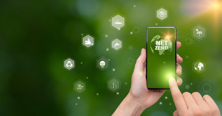 Smart phone in hand on green bokeh background. Technology concept.の写真素材