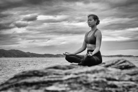 Yoga on the rock at the sunset with the murmur of waves, B&Wの写真素材