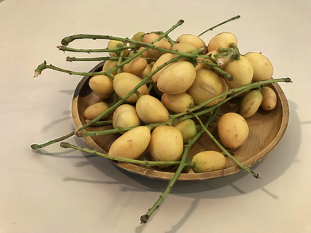 Rambai fruit in wood plate on the white table