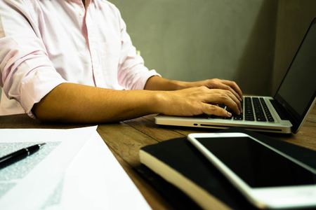 Close up hands man using laptop on the table.