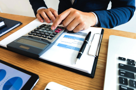 Businessmen calculate the income from the export business on the wood table.Business concept.の写真素材