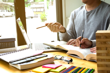 Students helps friend teaching and learning subject additional in library. using laptop to the education . education concept.の写真素材