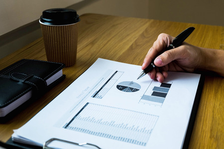 Businessman working with income statement document on the wood table.Business concept.