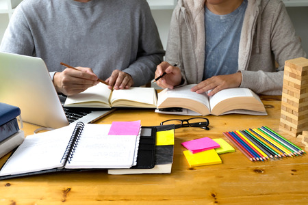 Students helps friend teaching and learning subject additional in library. Education concept.の写真素材