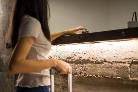 Close up women call hotel reception on counter desk with finger push a bell in lobby hotel. hotel concept.の写真素材