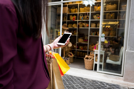 Woman holding shopping bag and using smartphone for shopping online, shopping concept.の写真素材