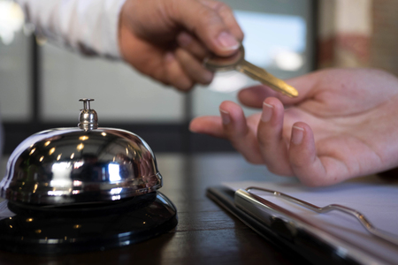 Close up of hand guest takes room key at check-in desk of the hotel.Hotel concept.の写真素材