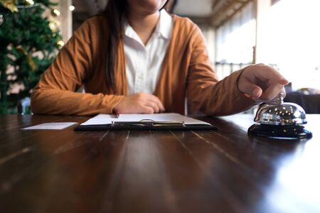 Women call hotel reception with finger push a bell in lobby hotel. hotel concept.の写真素材