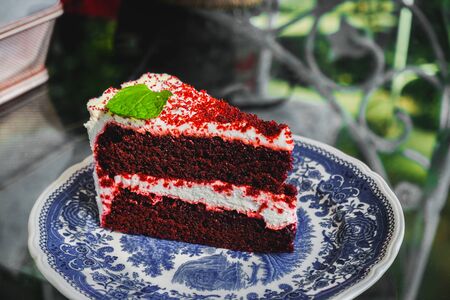 Close up of Red Velvet cake and icing that serve on the plate with mine leaf. Sweeties time.