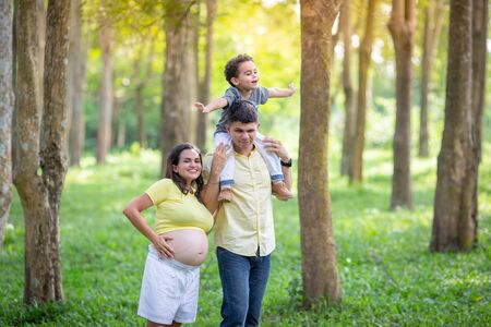 Young family is happy. While spending time in the park And a baby in the womb.の写真素材