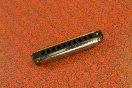Harmonica put on a red background