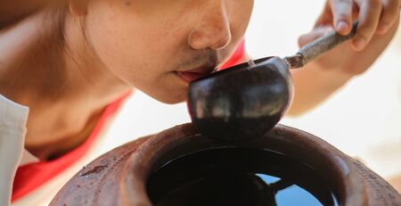 Wooden water dipper made from coconut shells,People are drinking waterの写真素材