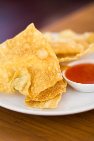 Deep fried wonton on white dish with sweet sauce の写真素材