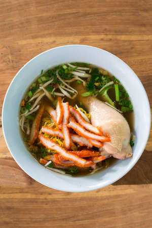 noodles with red porkl and chicken on wood tableの写真素材