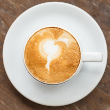 Hot Cup of Coffee on a Wooden Tableの写真素材