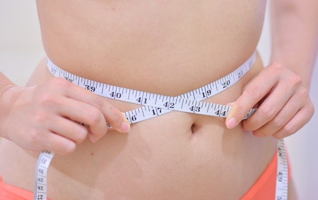 woman measuring her waist 