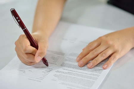 sitting at office desk signing the contract to conclude a dealの写真素材