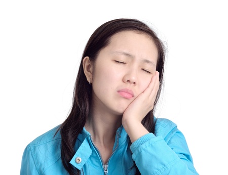 woman pressing her  cheek with a painful expression as if she s having a terrible tooth acheの写真素材