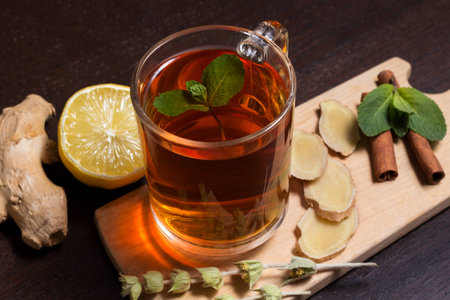 Cup of healthy ginger tea with mint and lemon on a wooden boardの写真素材
