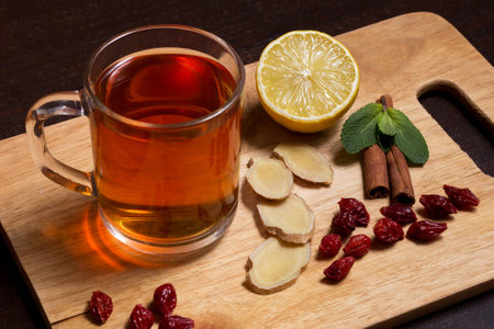 Cup of healthy ginger tea with mint and lemon on a wooden boardの写真素材