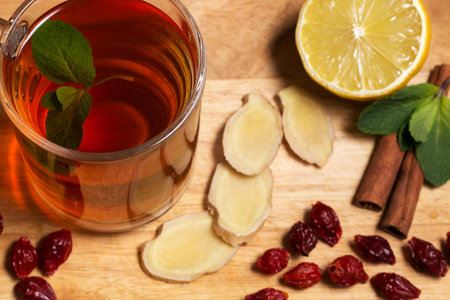 Cup of healthy ginger tea with mint and lemon on a wooden boardの写真素材