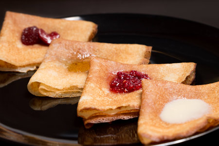 mPancakes with strawberry jam, raspberry jam, sour cream and honeyの写真素材