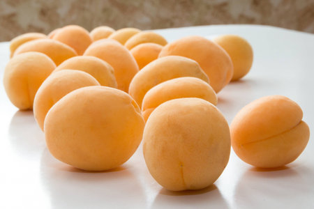 Apricot. A row of fresh fruits on a white tableの写真素材