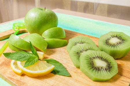 Ingredients for smoothie. Apple, kiwi, lemon and mint on wooden boardの写真素材