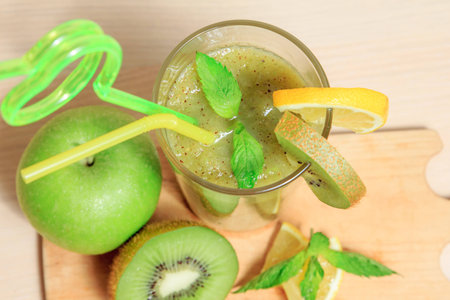 Green apple and kiwi smoothie with lemon and mint in a glassの写真素材