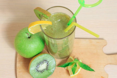 Green apple and kiwi smoothie with lemon and mint in a glassの写真素材