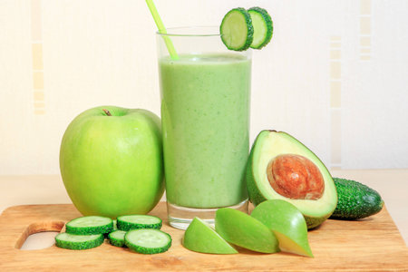 Green smoothie with apple, avocado and cucumber in a glassの写真素材