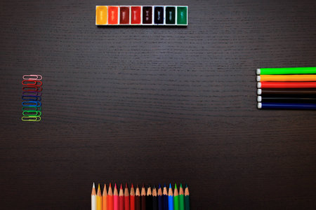 Color pencils, paints, clips and markers on a dark background with a spece for your textの写真素材