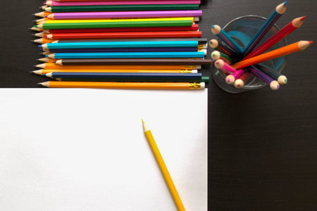 Colored pencils and sheet of paper on dark backgroundの写真素材