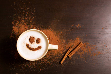 Cup of coffee with smile pattern of cinnamon on dark backgroundの写真素材
