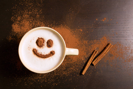 Cup of coffee with smile pattern of cinnamon on dark backgroundの写真素材