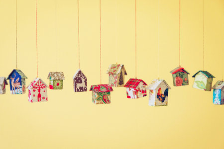 Fir tree decoration: handmade houses with Christmas ornaments hanging on a stringの写真素材