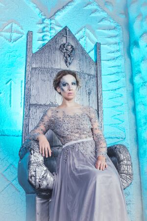 Beautiful winter snow queen on throne on a blue backgroundの写真素材
