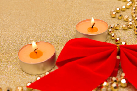 New year composition: gold paper, red bow, chaplet and candlesの写真素材