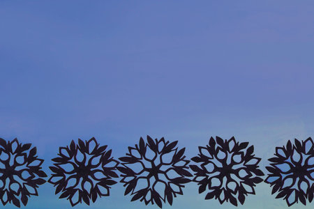 Blue New Year and Christmas background with black snowflakes for your textの写真素材
