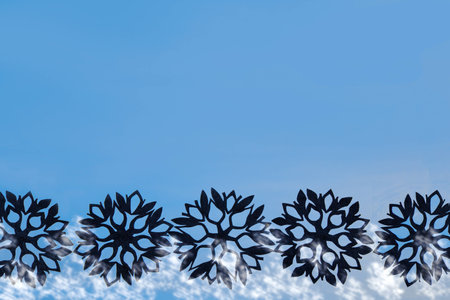Blue New Year and Christmas background with black snowflakes for your textの写真素材