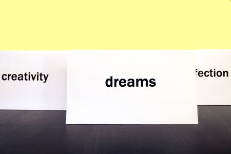 Word Dreams on a white paper card surrounded by other words. Priorities and values conceptの写真素材