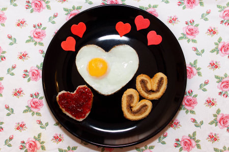 Composition of the biscuits, sandwich with jam, and scrambled egg in a heart shape. Valentine's Dayの写真素材